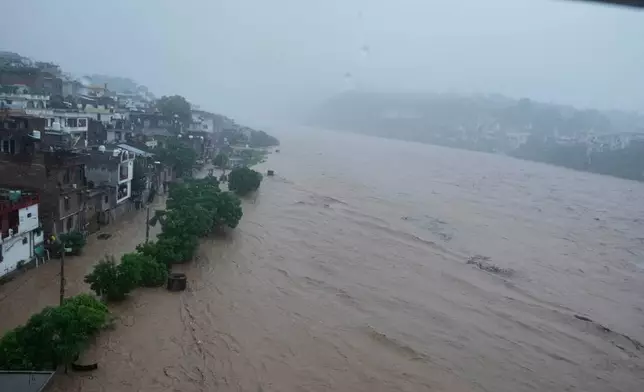 A swelling River Tawi following heavy rains in Jammu, India, Tuesday, Aug 26, 2025.(AP Photo/Channi Anand)