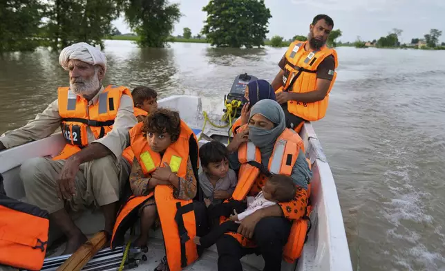 A rescue worker evacuates villagers from a flooded area in Dhoop Sarhi village in Kasur district, Pakistan, Tuesday, Aug. 26, 2025, due to the rising water level in Sutlej River, following neighboring India releasing water from overflowing dams. (AP Photo/K.M. Chaudary)