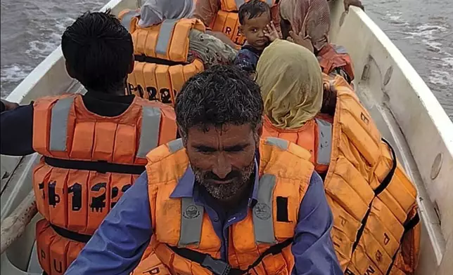 In this photo released by Pakistan's National Disaster Management Authority, rescue workers evacuate villagers from a low-lying area due to rising water level in the Sutlej River following neighbouring India released water from overflowing dams, in Bahawalnagar a district in Pakistan's Punjab province bordering India, Tuesday, Aug. 26, 2025. (Pakistan's National Disaster Management Authority via AP)