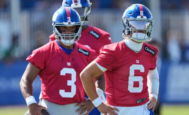 New York Giants quarterback Jaxson Dart, right, Russell Wilson, left, and Jameis Winston, rear, looking during pracice at the team's NFL football training camp in East Rutherford, N.J., Thursday, July 24, 2025. (AP Photo/Seth Wenig)