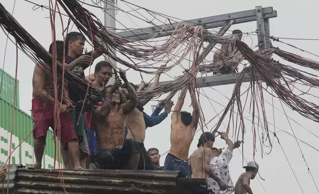 Residents salvage electrical wire which they will sell later after a fire hit a poor community in Manila, Philippines, on Wednesday, Aug. 6, 2025. (AP Photo/Aaron Favila)