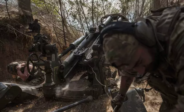 Ukrainian servicemen of the 148th artillery brigade fire from a M777 howitzer towards Russian positions at the frontline in Zaporizhzhia region, Ukraine, on Thursday, Aug. 7, 2025. (AP Photo/Evgeniy Maloletka)