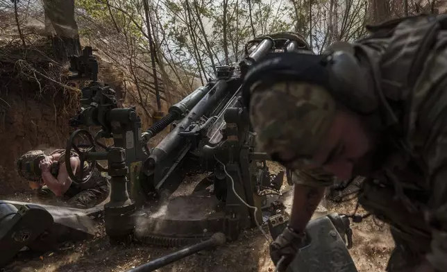 Ukrainian servicemen of the 148th artillery brigade fire from a M777 howitzer towards Russian positions at the frontline in Zaporizhzhia region, Ukraine, on Thursday, Aug. 7, 2025. (AP Photo/Evgeniy Maloletka)