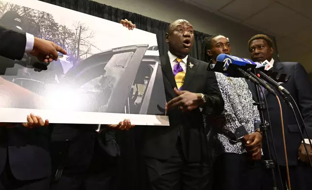 William McNeil Jr.'s attorney Ben Crump, center, speaks while showing a still from a police body cam video during a press conference Tuesday, July 29, 2025, in Chicago. (AP Photo/Paul Beaty)