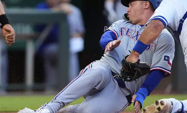 Texas Rangers' Joc Pederson is tagged out by Kansas City Royals catcher Luke Maile as he tried to score on fly out hit by Josh Smith during the second inning of a baseball game Monday, Aug. 18, 2025, in Kansas City, Mo. (AP Photo/Charlie Riedel)