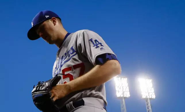 FILE - Los Angeles Dodgers starting pitcher Alex Wood walks back into the dugout after the seventh inning of a baseball game against the Cincinnati Reds, June 16, 2017, in Cincinnati. (AP Photo/John Minchillo, File)