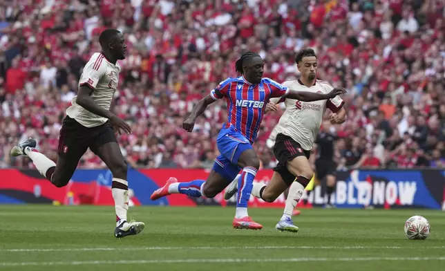 Crystal Palace's Eberechi Eze in action between Crystal Palace's Nathaniel Clyne, left, and Maxence Lacroix during the FA Community Shield final soccer match between Liverpool and Crystal Palace at Wembley Stadium in London,Sunday, Aug. 10, 2025. (AP Photo/Dave Shopland)