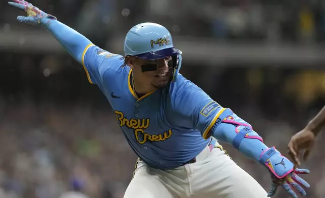Milwaukee Brewers' William Contreras celebrates with first base coach Julio Borbon after hitting a two-run home run during the seventh inning of a baseball game against the New York Mets, Saturday, Aug. 9, 2025, in Milwaukee. (AP Photo/Aaron Gash)