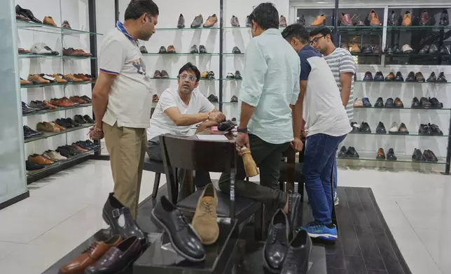 Sambhav Dawar, a senior manager, talks to his production line supervisors at the Dawar leather footwear manufacturing industry in Agra, India, Monday, Aug. 25, 2025. (AP Photo/Manish Swarup)