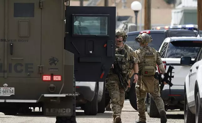 Law enforcement personnel respond to a reported shooting in Anaconda, Mont., Friday, Aug. 1, 2025. (Joseph Scheller/The Montana Standard via AP)