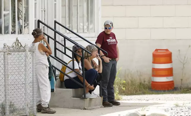People are seen in the town of Anaconda, Mont., following a reported shooting, Friday, Aug. 1, 2025. (Joseph Scheller/The Montana Standard via AP)