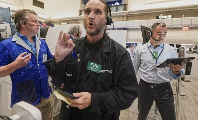 Options trader Chris Dattolo, center, works with colleagues on the floor of the New York Stock Exchange, Monday, Aug. 18, 2025. (AP Photo/Richard Drew)