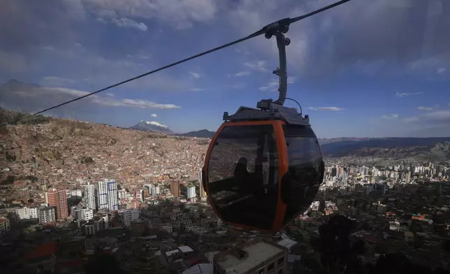 Cable cars carry passengers above La Paz, Bolivia, Monday, Aug. 11, 2025, six days ahead of presidential elections. (AP Photo/Juan Karita)