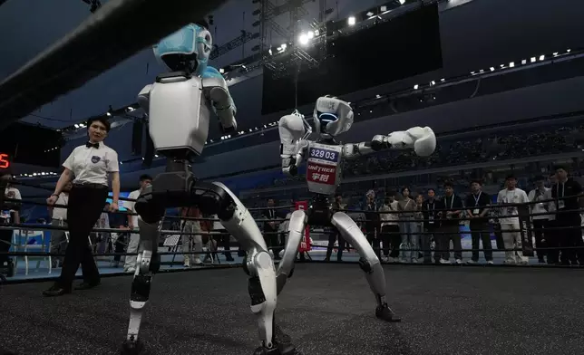 Robots compete at the Free Combat event of the World Humanoid Robot Games held in Beijing, China, Friday, Aug. 15, 2025. (AP Photo/Ng Han Guan)