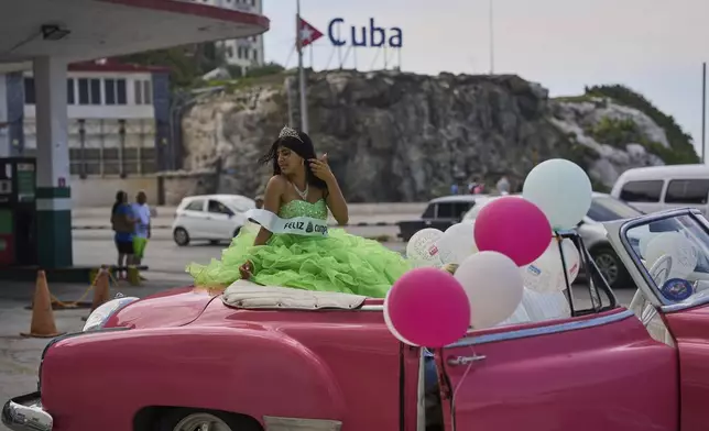 Joselin Marlen Martinez poses on top of a classic American car before her quinceanera photoshoot in Havana, Monday, Aug. 11, 2025. (AP Photo/Ramon Espinosa)