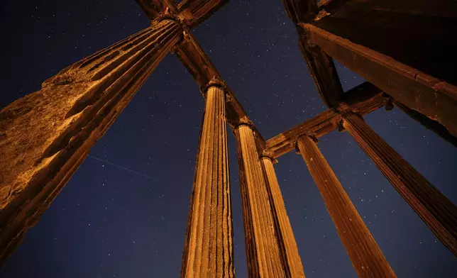 A meteor streaks across the sky, seen above the Temple of Zeus in the ancient city of Aizanoi, during the Perseid meteor shower, near Cavdarhisar, western Turkey, Tuesday, Aug. 12, 2025. (AP Photo/Emrah Gurel)