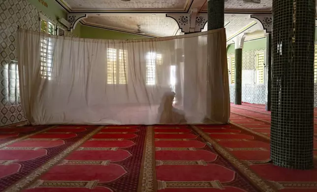 A woman prays in the designated women's section at the Great Mosque of Nietty Mbar in Thiaroye, a suburb of Dakar, Senegal, Friday, July 4, 2025.(AP Photo/Sylvain Cherkaoui)