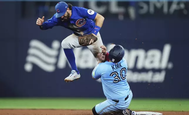 Toronto Blue Jays' Alejandro Kirk, right, slides safely into second base as Chicago Cubs shortstop Dansby Swanson (7) defends during the fifth inning of a baseball game in Toronto on Tuesday, Aug. 12, 2025. (Nathan Denette/The Canadian Press via AP)