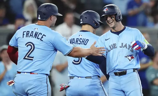 Toronto Blue Jays' Ernie Clement (right) celebrates his three-run home run against the Chicago Cubs with Ty France (2) and Daulton Varsho (5) during fourth inning MLB baseball action in Toronto on Tuesday, August 12, 2025. (Nathan Denette/The Canadian Press via AP)