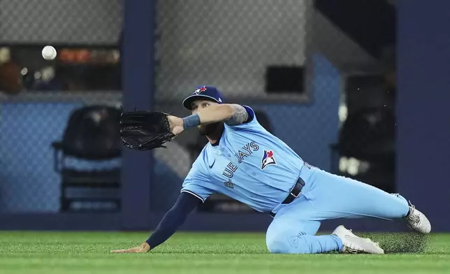 Toronto Blue Jays outfielder Nathan Lukes (38) makes a diving catch against the Chicago Cubs during second inning MLB baseball action in Toronto on Tuesday, August 12, 2025. (Nathan Denette/The Canadian Press via AP)