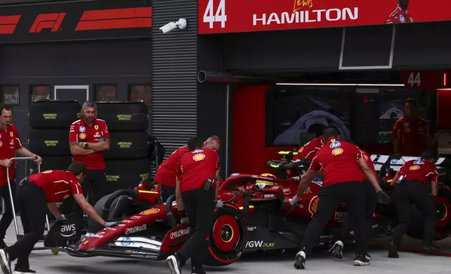 Ferrari driver Lewis Hamilton of Britain gets pushed back into his garage during the qualifying session for the Hungarian Formula One Grand Prix at the Hungaroring racetrack in Mogyorod, Hungary, Saturday, Aug. 2, 2025. (Anna Szilagyi/Pool Photo via AP)