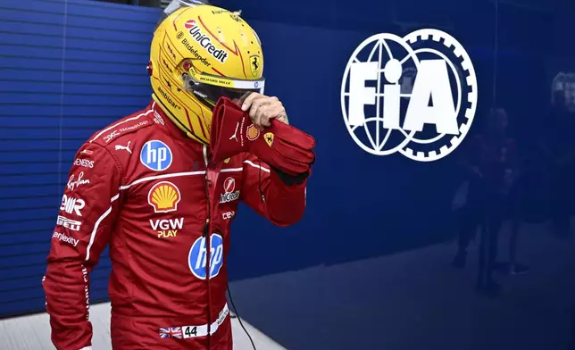 Ferrari driver Lewis Hamilton of Britain walks back to his pits after failing to complete during the qualifying session for the Hungarian Formula One Grand Prix at the Hungaroring racetrack in Mogyorod, Hungary, Saturday, Aug. 2, 2025. (AP Photo/Denes Erdos)