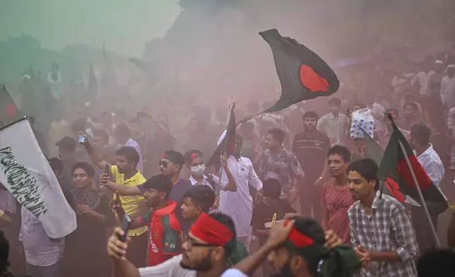 People use colored sprays as they gather to commemorate "July Uprising Day" marking the anniversary of the fall of the Awami League government, in Dhaka, Bangladesh, Tuesday, Aug. 5, 2025. (AP Photo/Mahmud Hossain Opu)