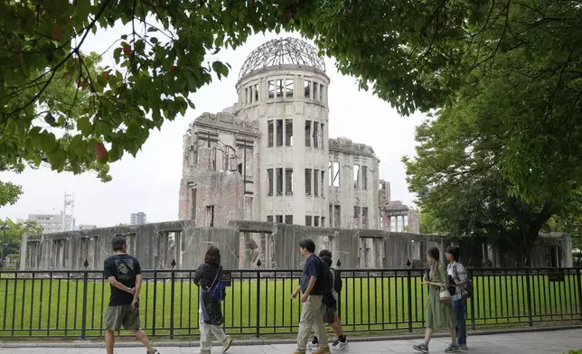 Tourists walk past the Atomic Bomb Dome on Wednesday, July 9, 2025 in Hiroshima, western Japan. (AP Photo/Eugene Hoshiko)