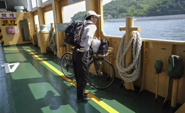 Rebun Kayo, a Hiroshima University researcher, takes the ferry to commute between Hiroshima and the island of Ninoshima to search for remains of victims of the 1945 atomic bombing in Ninoshima in Hiroshima, western Japan, Tuesday, July 8, 2025. (AP Photo/Eugene Hoshiko)