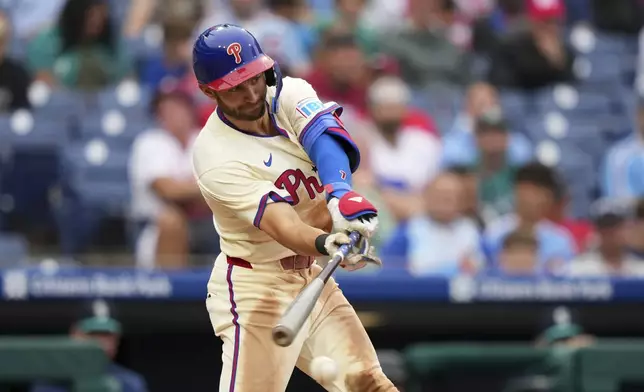 Philadelphia Phillies' Trea Turner hits a run-scoring single against Seattle Mariners pitcher Sauryn Lao during the eighth inning of a baseball game Wednesday, Aug. 20, 2025, in Philadelphia. (AP Photo/Matt Slocum)