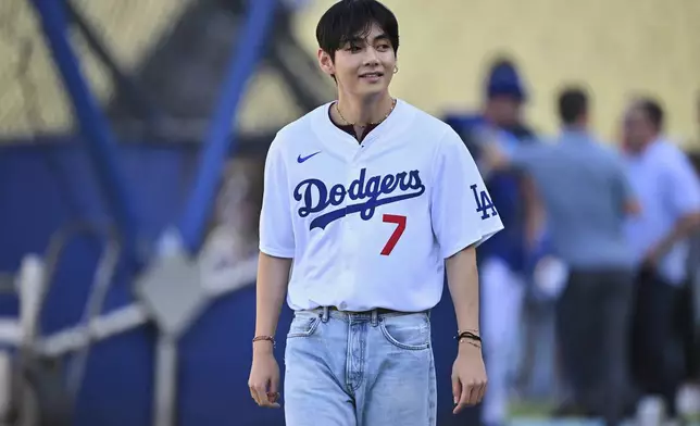 V, a member of the South Korean K-pop band BTS, looks on during batting practice before a baseball game between the Los Angeles Dodgers and the Cincinnati Reds Monday, Aug. 25, 2025, in Los Angeles. (AP Photo/Jayne Kamin-Oncea)