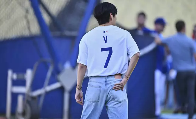 V, a member of the South Korean K-pop band BTS, looks on during batting practice before a baseball game between the Los Angeles Dodgers and the Cincinnati Reds Monday, Aug. 25, 2025, in Los Angeles. (AP Photo/Jayne Kamin-Oncea)