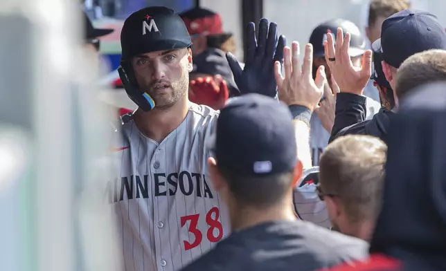 Minnesota Twins' Matt Wallner (38) is congratulated by teammates after hitting a two-run home run off Cleveland Guardians starting pitcher Tanner Bibee during the fourth inning of a baseball game, Saturday, Aug. 2, 2025, in Cleveland. (AP Photo/Phil Long)