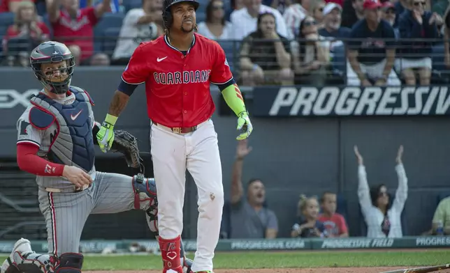 Cleveland Guardians' Jose Ramirez, right, watches his two-run home run off Minnesota Twins starting pitcher Bailey Ober along with Twins' Ryan Jeffers, left, during the fifth inning of a baseball game, Saturday, Aug. 2, 2025, in Cleveland. (AP Photo/Phil Long)