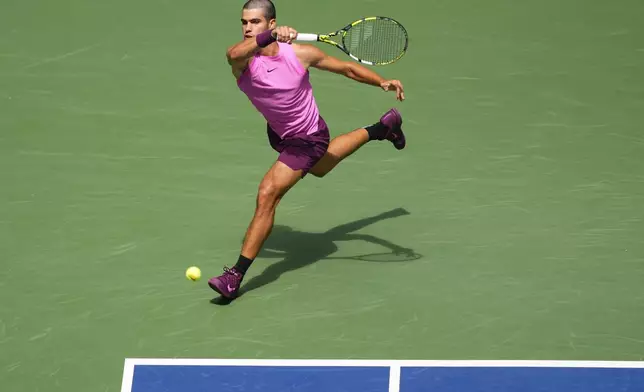 Carlos Alcaraz, of Spain, returns a shot to Luciano Darderi, of Italy, during the third round of the U.S. Open tennis championships, Friday, Aug. 29, 2025, in New York. (AP Photo/Yuki Iwamura)