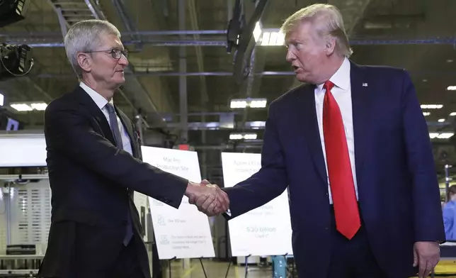 FILE - Apple CEO Tim Cook and President Donald Trump shake hands during a tour of an Apple manufacturing plant, Nov. 20, 2019, in Austin. (AP Photo/ Evan Vucci, File)