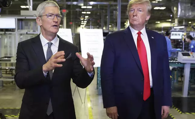 FILE - Apple CEO Tim Cook and President Donald Trump speak during a tour of an Apple manufacturing plant, Nov. 20, 2019, in Austin. (AP Photo/ Evan Vucci, FIle)