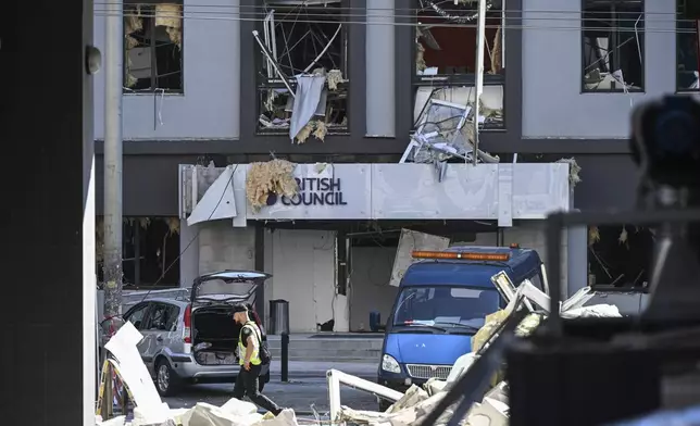 A police officer passes by the British Council building after it was hit during Russian missile and drone attacks in central Kyiv, Ukraine, Thursday, Aug. 28, 2025 (AP Photo/Danylo Antoniuk)