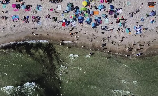 Crowds gather along the Baltic Sea shoreline in Scharbeutz, northern Germany. Aug. 13, 2025. (AP Photo/Michael Probst)