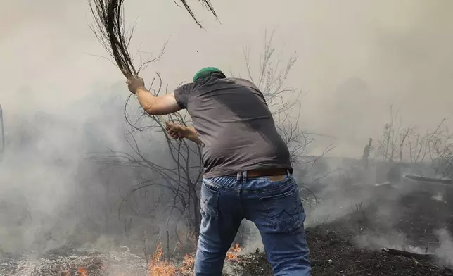 A man battles a wildfire in Veiga das Meas, northwestern Spain, Aug. 16, 2025. (AP Photo/Lalo R. Villar)