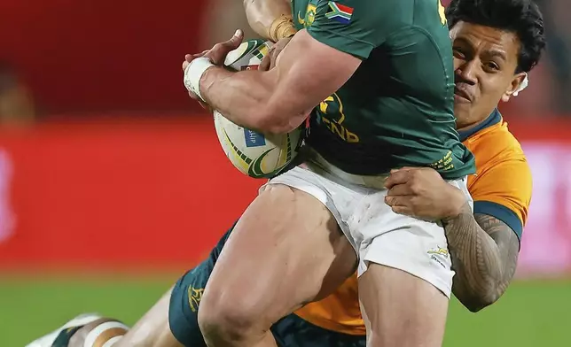 South Africa's Jesse Kriel, front, is tackled by Australia's Len Ikitau during a rugby championship test match at Ellis Park stadium in Johannesburg, South Africa, Aug. 16, 2025. (AP Photo/Frans Lombard)