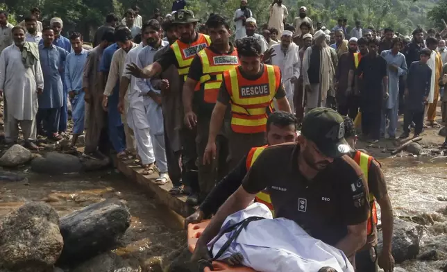 Rescue workers transport the body of a victim recovered from the rubble of a home destroyed by flash flooding in Qadir Nagar, near Pir Baba, Pakistan, Aug. 16, 2025. (AP Photo/Muhammad Sajjad)