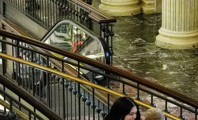 District of Columbia National Guard soldiers patrol inside Union Station as a couple pose for their engagement photos, in Washington, Aug. 16, 2025. (AP Photo/Julia Demaree Nikhinson)