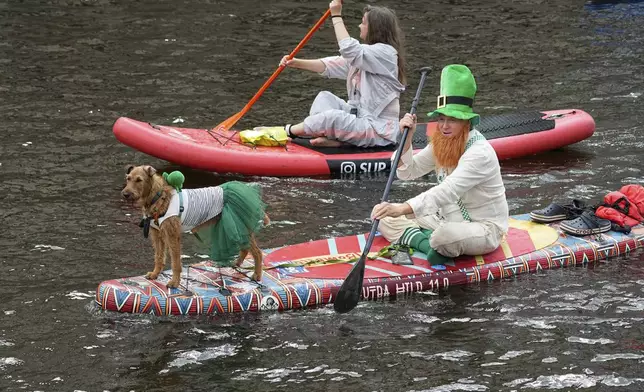 People steer their stand-up paddle (SUP) boards along the Moyka River at the annual costumed 'Fontanka' SUP-boards festival attracting more than 10,000 participants, in St. Petersburg, Russia, Saturday, Aug. 2, 2025. (AP Photo/Dmitri Lovetsky)