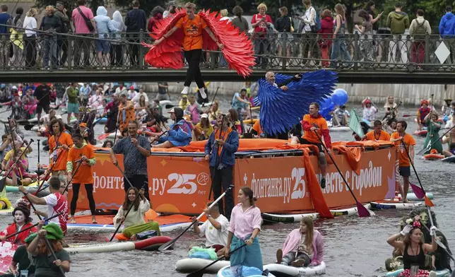 A boy jumps on a trampoline floating along the Moyka River at the annual costumed 'Fontanka' SUP-boards festival attracting more than 10,000 participants, in St. Petersburg, Russia, Saturday, Aug. 2, 2025. (AP Photo/Dmitri Lovetsky)