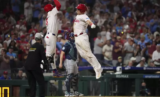 Philadelphia Phillies' J.T. Realmuto, right, and Bryce Harper celebrate after Realmuto's two-run home run against Seattle Mariners pitcher Matt Brash during the eighth inning of a baseball game Tuesday, Aug. 19, 2025, in Philadelphia. (AP Photo/Matt Slocum)