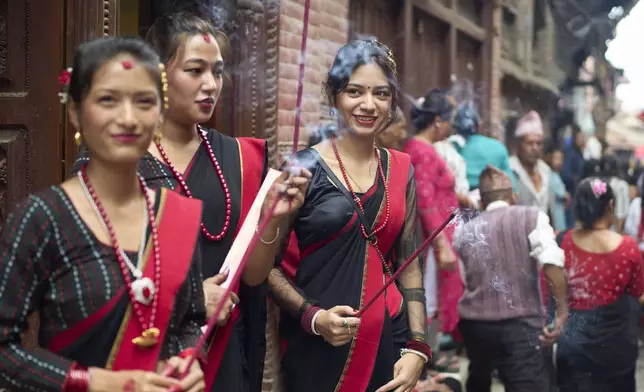 Devotees light incense during a parade celebrating the birthday of Lord Krishna on Krishna Janmashtami in Bhaktapur,Nepal, Saturday, Aug. 16, 2025. (AP Photo/Niranjan Shrestha)