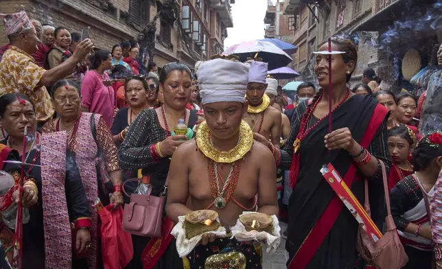 Devotees light oil lamps on their head during a parade celebrating the birthday of Lord Krishna on Krishna Janmashtami in Bhaktapur,Nepal, Saturday, Aug. 16, 2025. (AP Photo/Niranjan Shrestha)