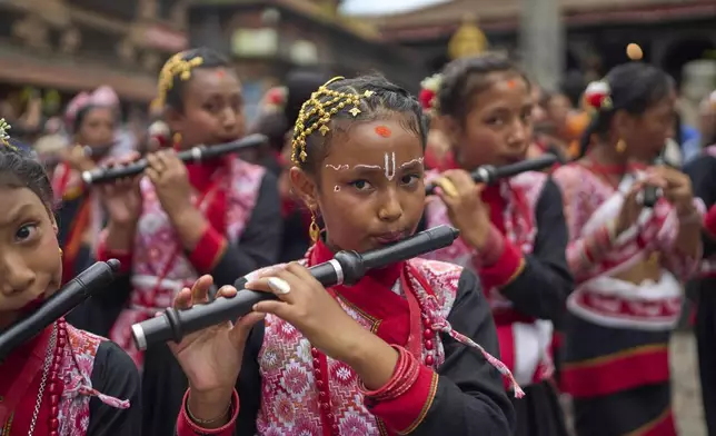 Young devotees play flute as they participate in a parade celebrating the birthday of Lord Krishna on Krishna Janmashtami in Bhaktapur,Nepal, Saturday, Aug. 16, 2025. (AP Photo/Niranjan Shrestha)