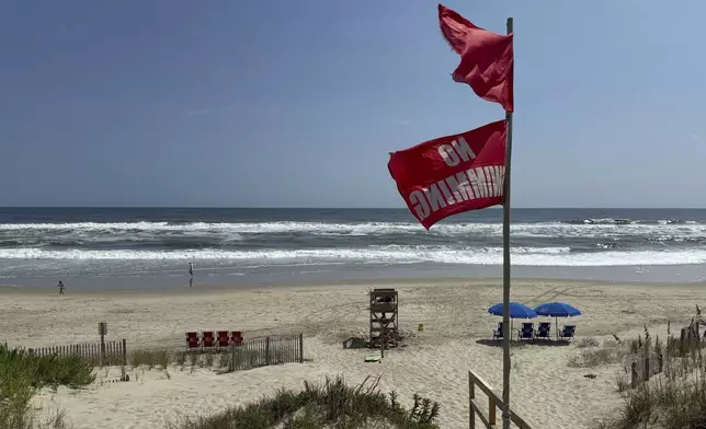Red flags, indicating swimming is prohibited, are raised at the beach in Duck, N.C., Tuesday, Aug. 19, 2025, as precautions are taken ahead of Hurricane Erin. (AP Photo/Pablo Martinez Monsivais)